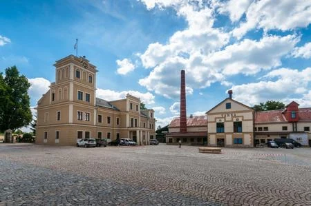 Pohled na budovu a dlážděný areál v Rohozci